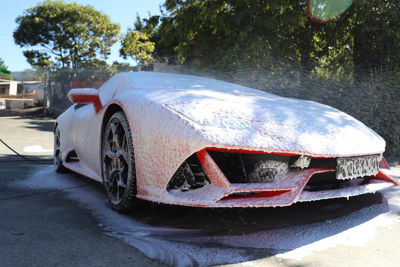 A car covered in snow foam during a full exterior wash