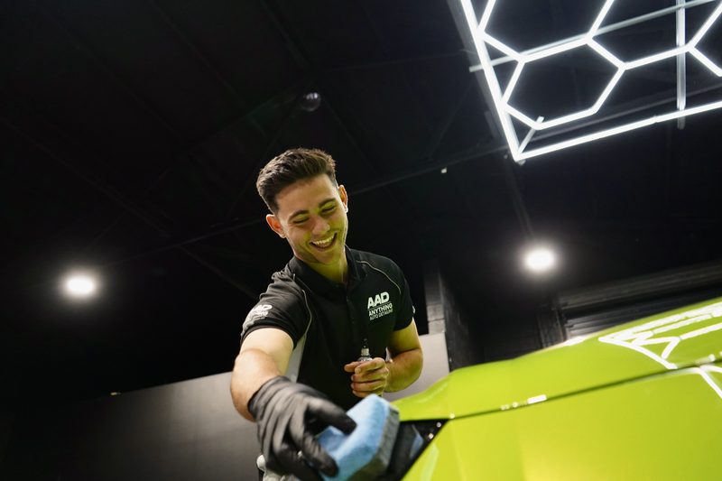An Anything Auto Detailing technician finishing a Lamborghini under the workshop lighting